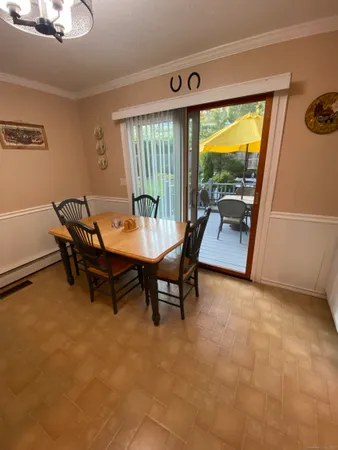 a dining room with furniture and a floor to ceiling window