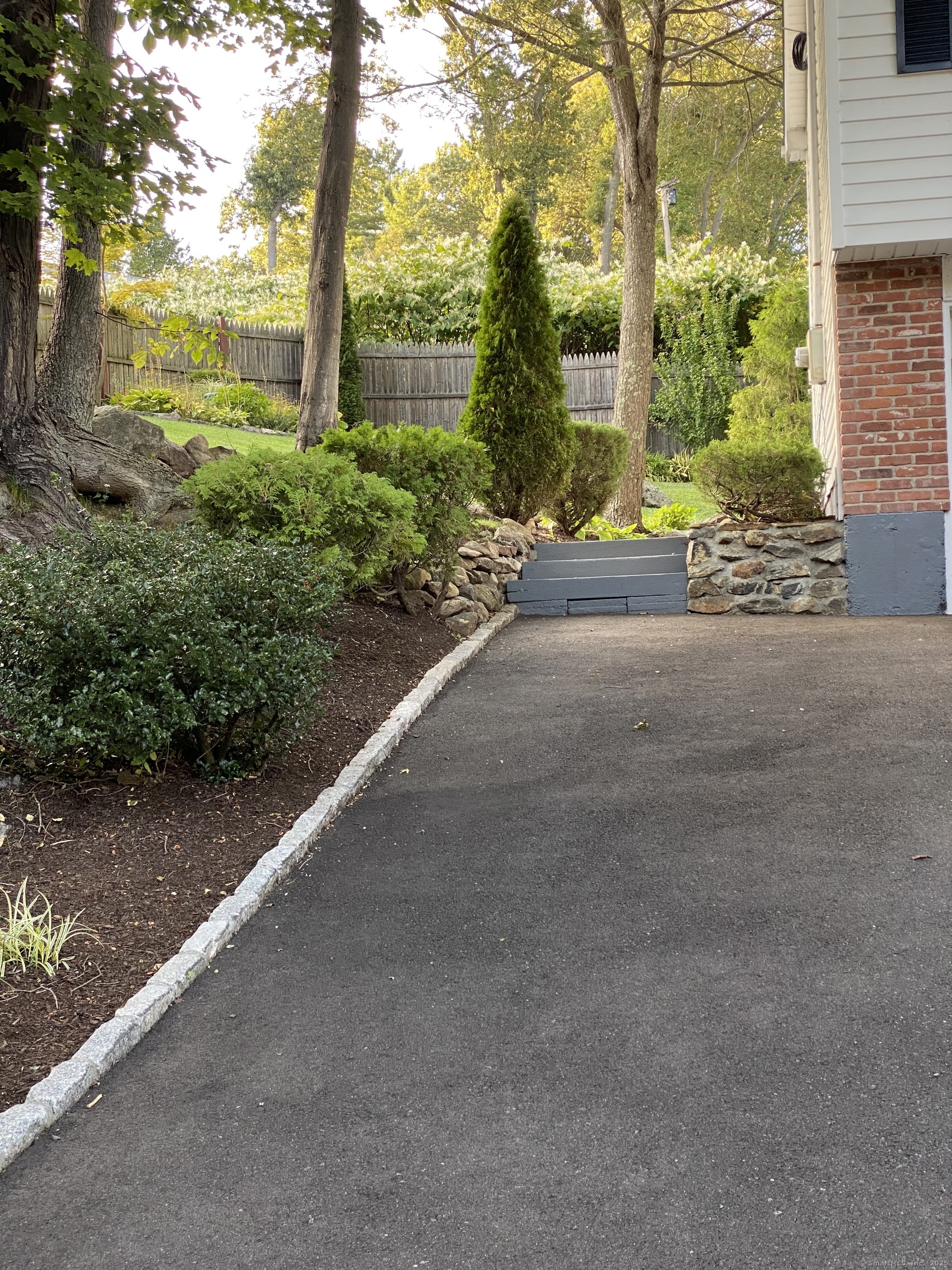 110 Wooster Avenue Waterbury, CT 06708 - Photo 4 of 35 a view of a garden with a bench in front of a yard