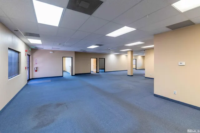 a view of a big room with wooden floor and windows