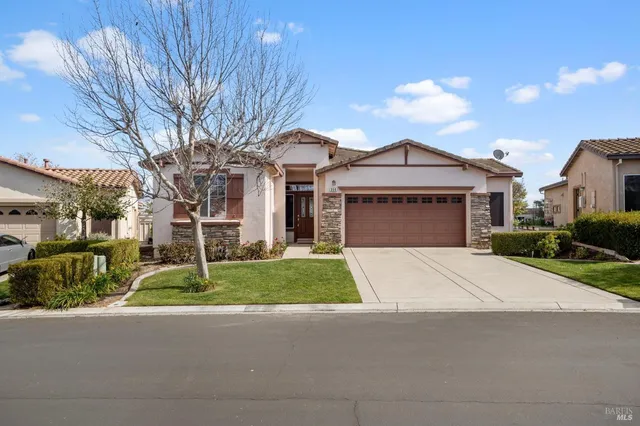 a front view of a house with a yard and garage