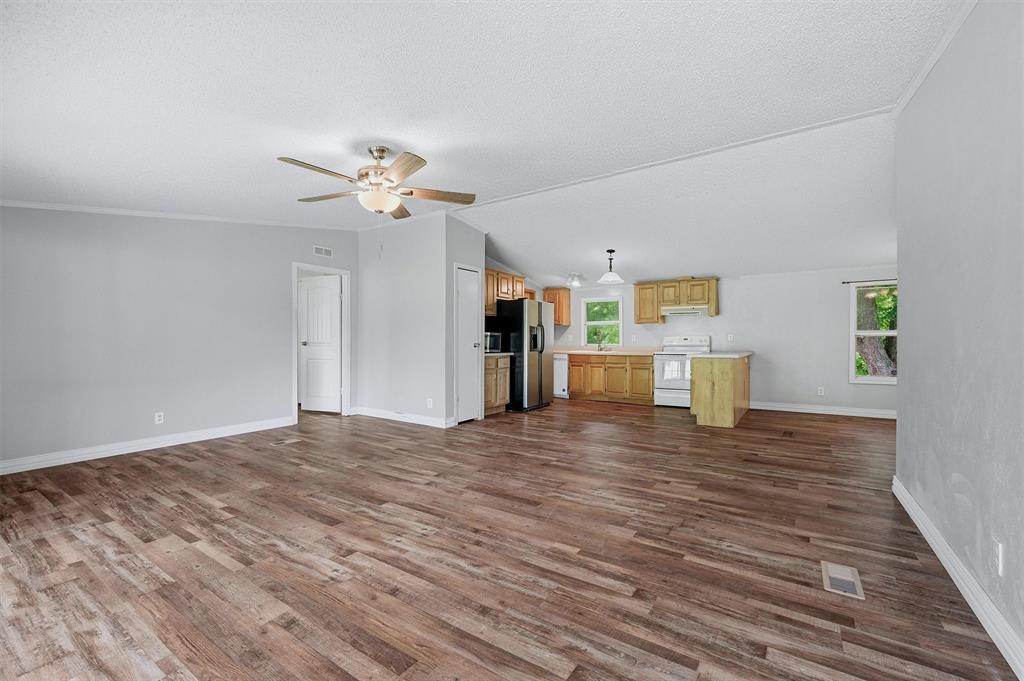150 Gilbreath Road Sadler, TX 76264 - Photo 6 of 34 a view of an empty room with a window and wooden floor