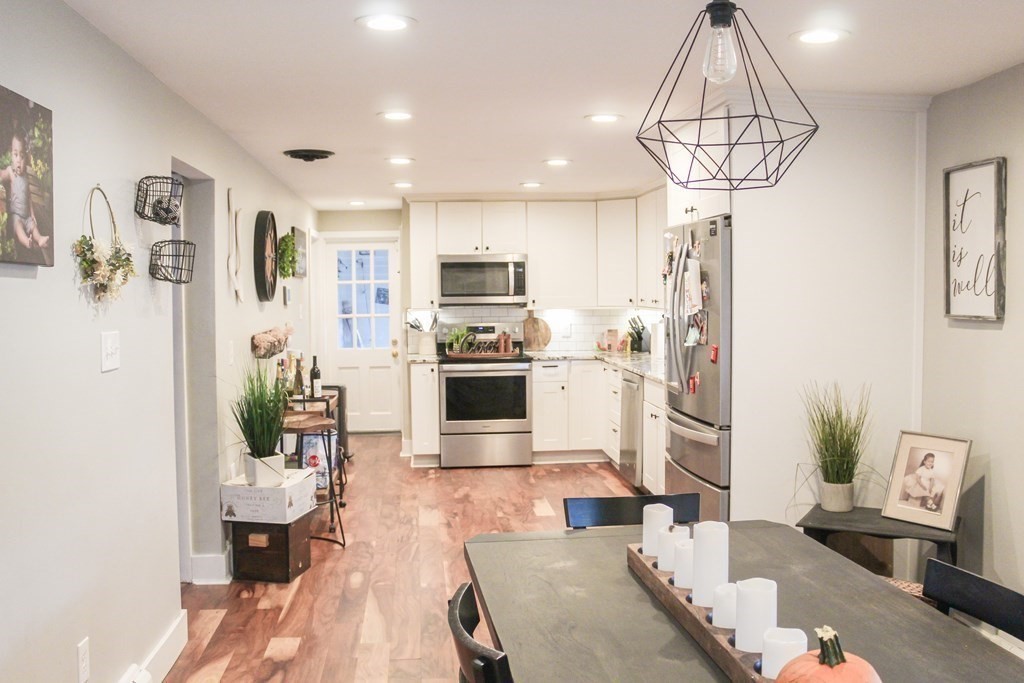 76 Embury Street Springfield, MA 01109 - Photo 6 of 18 a kitchen with stainless steel appliances a dining table chairs sink and refrigerator