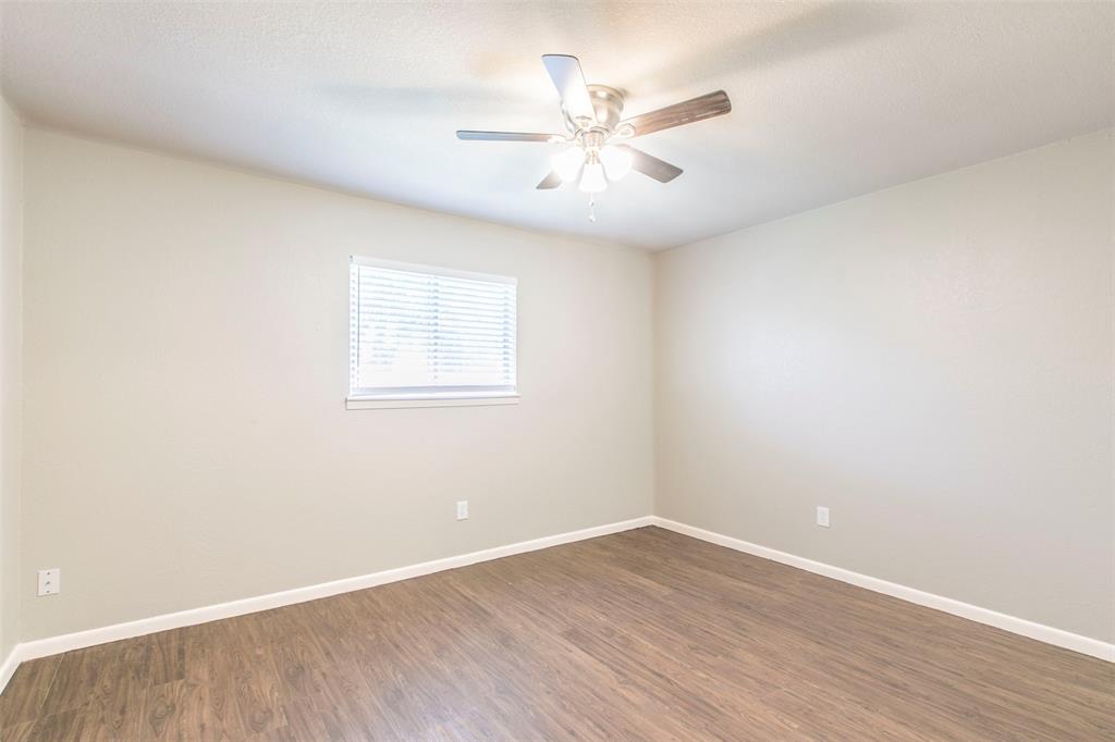 600-614 Riggins Street Robinson, TX 76706 - Photo 12 of 16 an empty room with wooden floor fan and windows