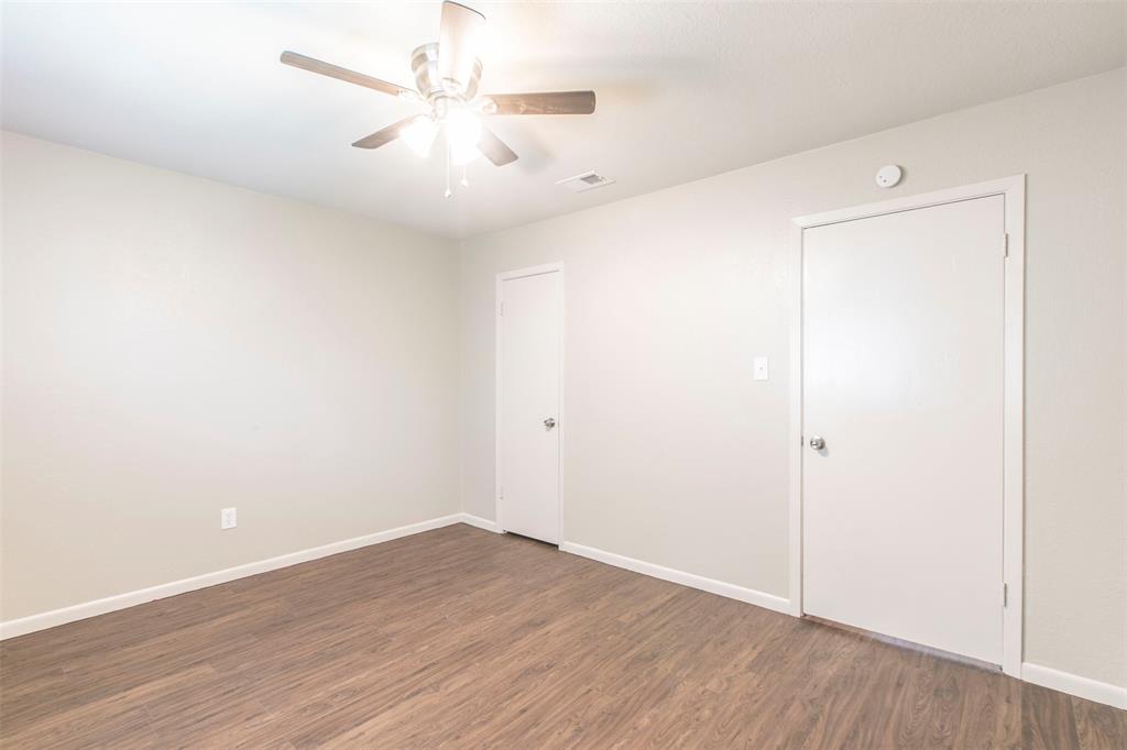 600-614 Riggins Street Robinson, TX 76706 - Photo 13 of 16 an empty room with wooden floor and fan