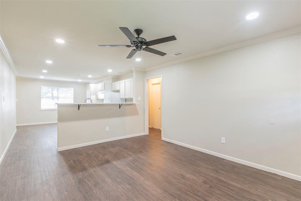 600-614 Riggins Street Robinson, TX 76706 - Photo 4 of 16 a view of an empty room with wooden floor and a window