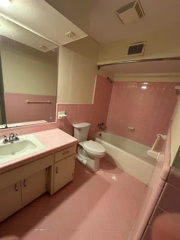 a bathroom with a granite countertop sink a toilet and a bathtub