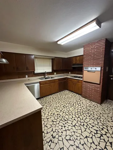 a kitchen with a sink a counter top space cabinets and stainless steel appliances