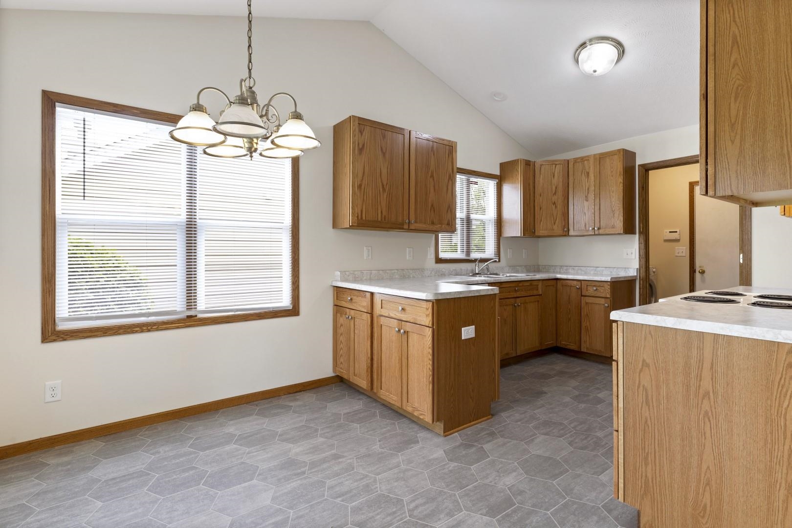 6682 North Point Road Rockford, IL 61108 - Photo 4 of 34 a kitchen with a refrigerator a sink dishwasher with wooden cabinets and a large window