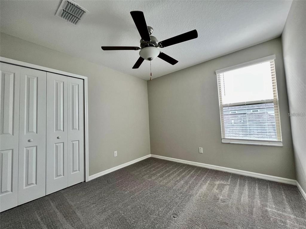 31730 Barrel Wave Way Wesley Chapel, FL 33545 - Photo 13 of 14 a view of an empty room with a ceiling fan