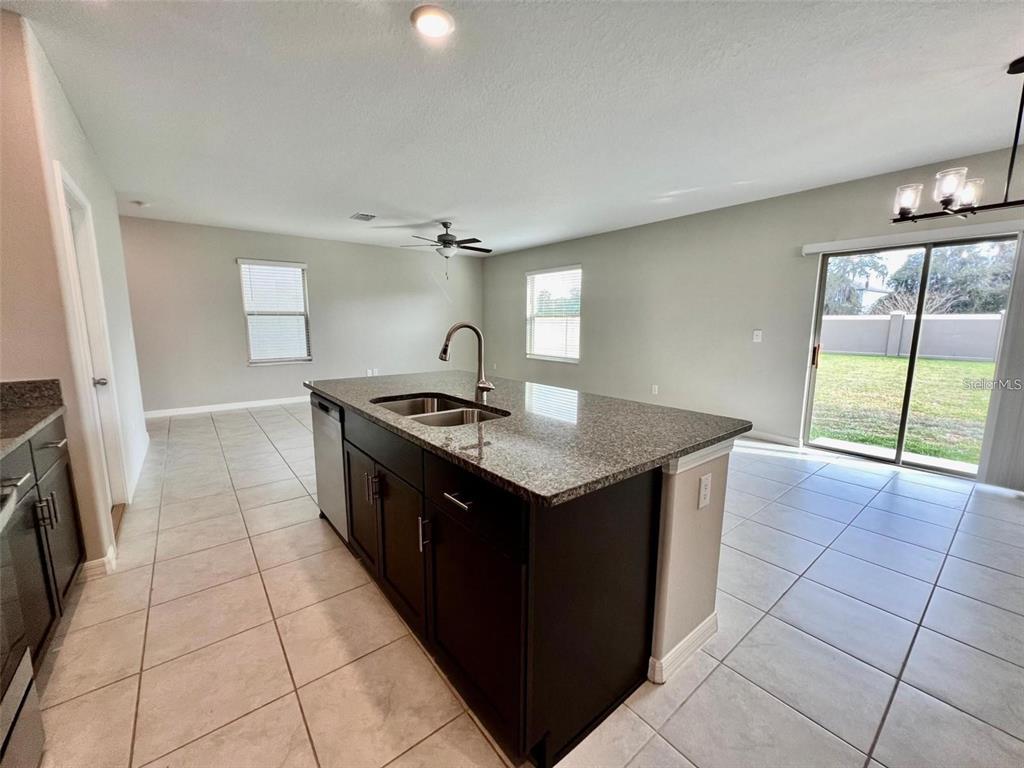 31730 Barrel Wave Way Wesley Chapel, FL 33545 - Photo 3 of 14 a kitchen with stainless steel appliances granite countertop a sink and a stove top oven