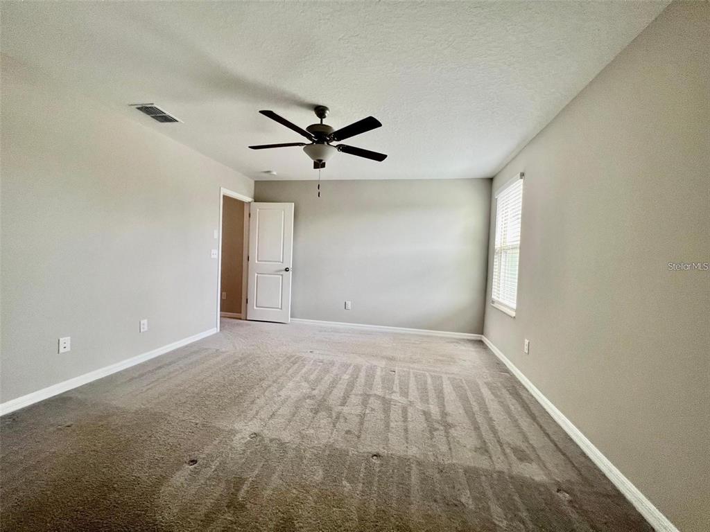 31730 Barrel Wave Way Wesley Chapel, FL 33545 - Photo 8 of 14 an empty room with a empty space and a ceiling fan