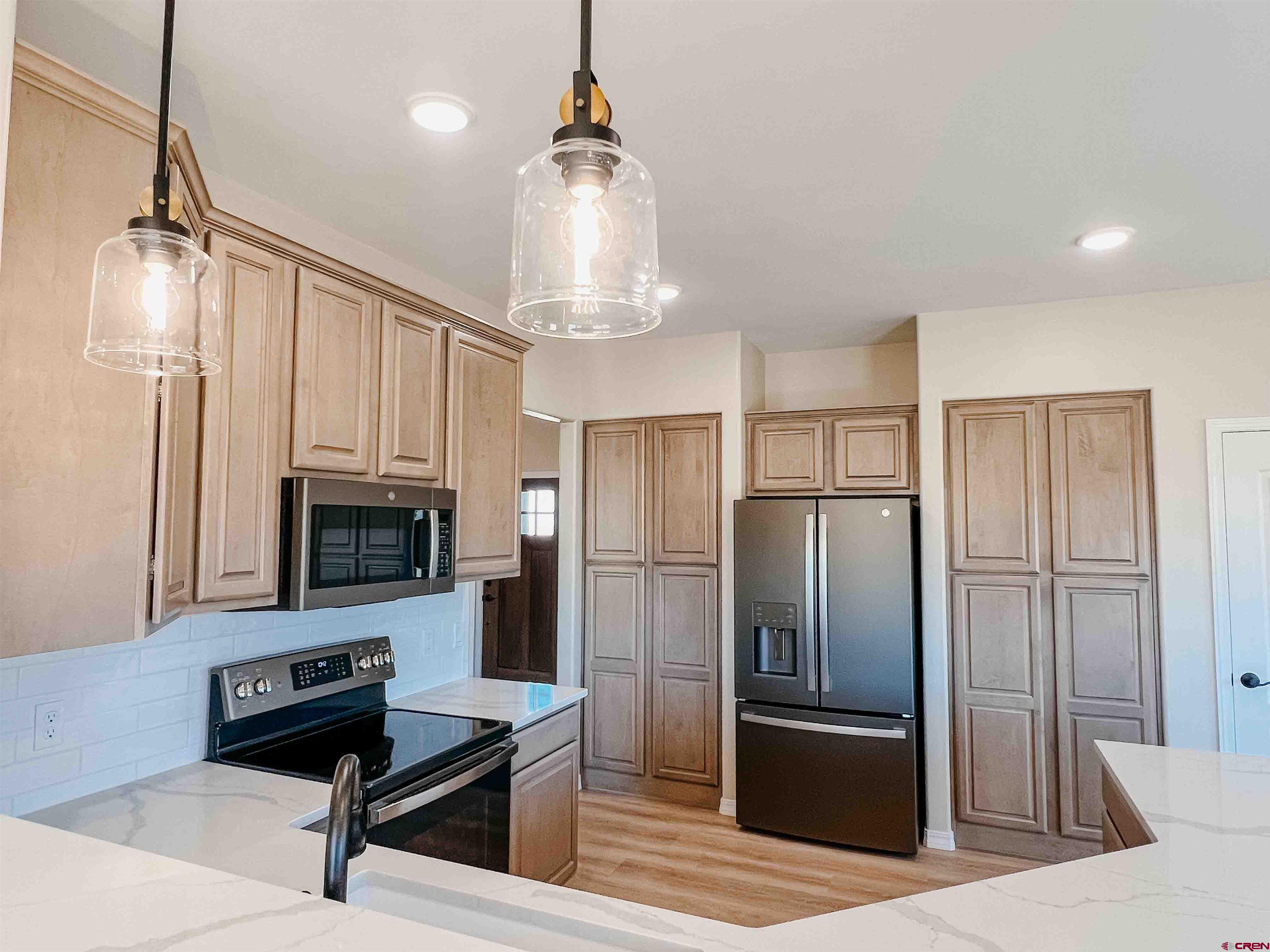 68364 Vernal Road Montrose, CO 81403 - Photo 4 of 11 a kitchen with stainless steel appliances a refrigerator and a stove top oven