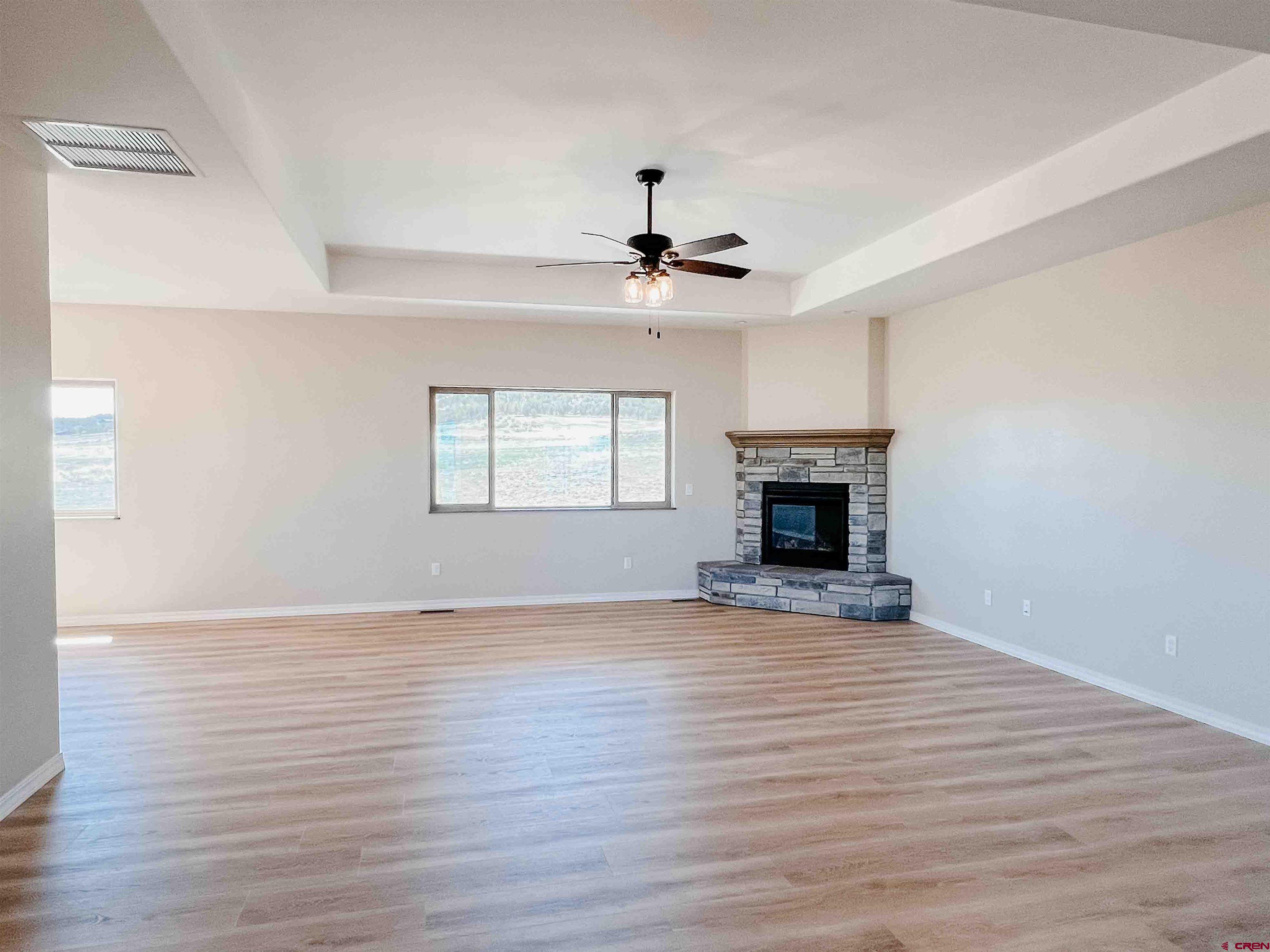 68364 Vernal Road Montrose, CO 81403 - Photo 5 of 11 a view of an empty room with wooden floor fireplace and a window