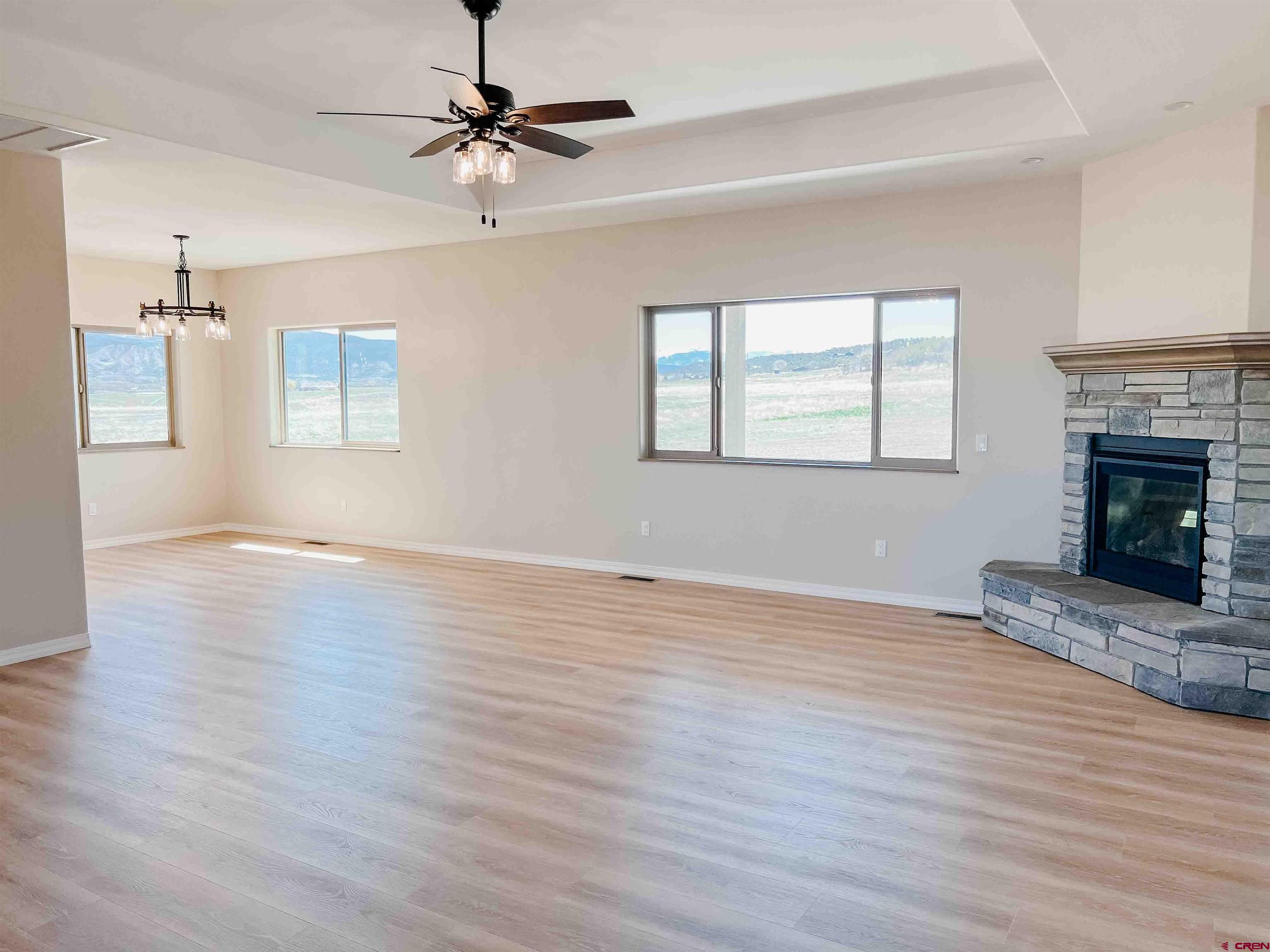 68364 Vernal Road Montrose, CO 81403 - Photo 6 of 11 a view of an empty room with wooden floor fireplace and a window