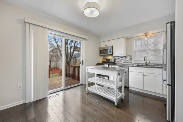 a kitchen with white cabinets and appliances