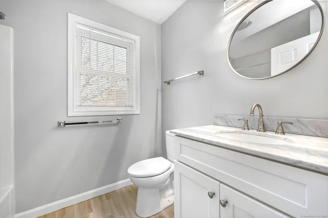 a bathroom with a granite countertop toilet sink and mirror