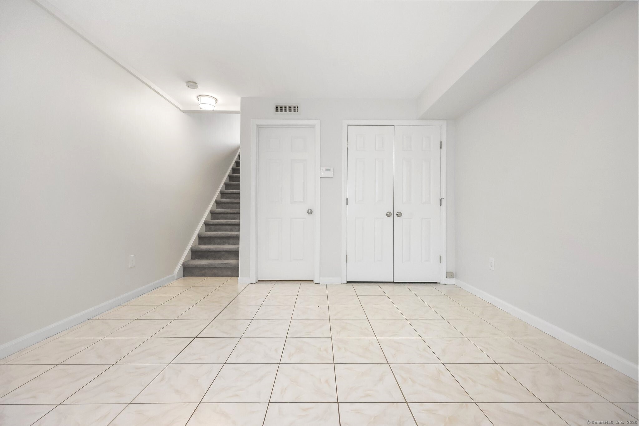 103 Dean Street Stamford, CT 06902 - Photo 8 of 11 an empty room with white walls and tiles