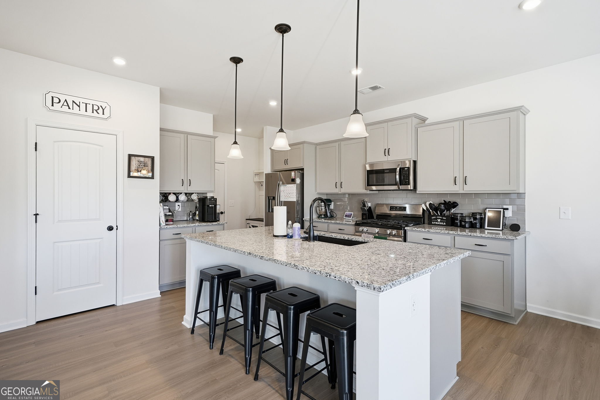 199 Graham Circle Adairsville, GA 30103 - Photo 12 of 49 a kitchen with stainless steel appliances granite countertop a stove a sink a refrigerator a center island a dining table and chairs with wooden floor