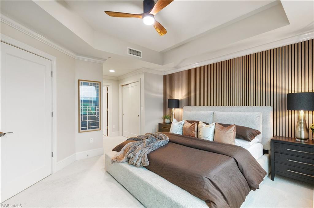 9115 Strada Place, Unit 5406 Naples, FL 34108 - Photo 20 of 50 a bedroom with a large bed and a chandelier