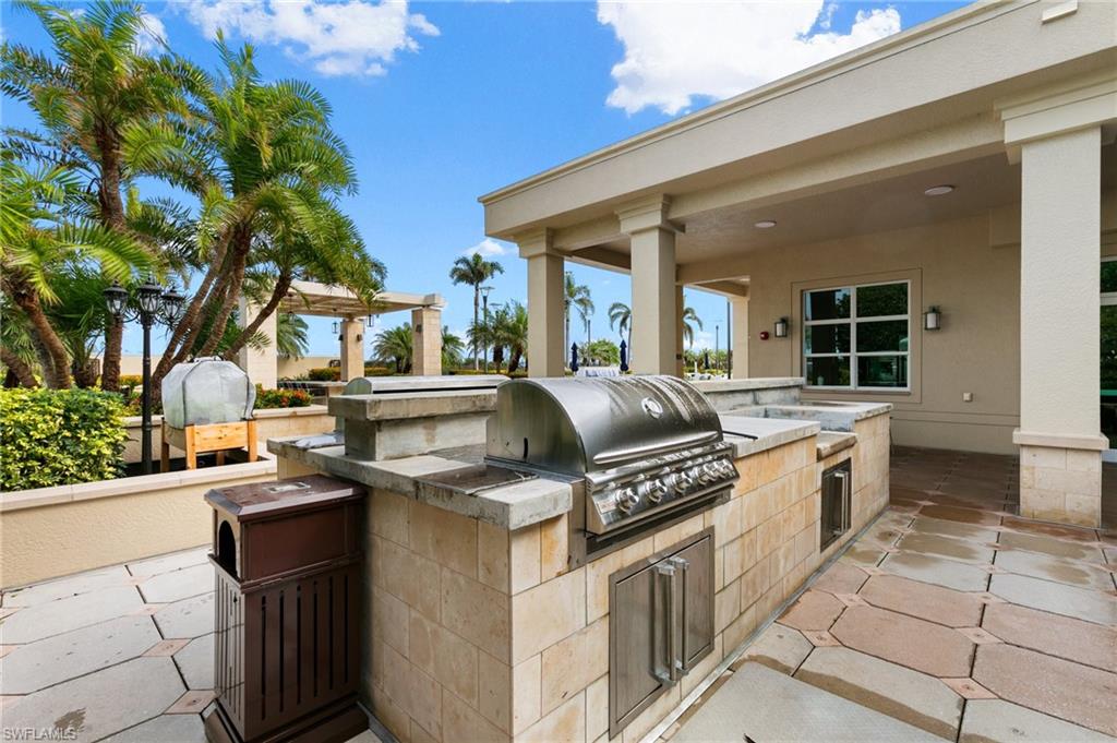 9115 Strada Place, Unit 5406 Naples, FL 34108 - Photo 45 of 50 a kitchen with stainless steel appliances granite countertop a sink and a stove