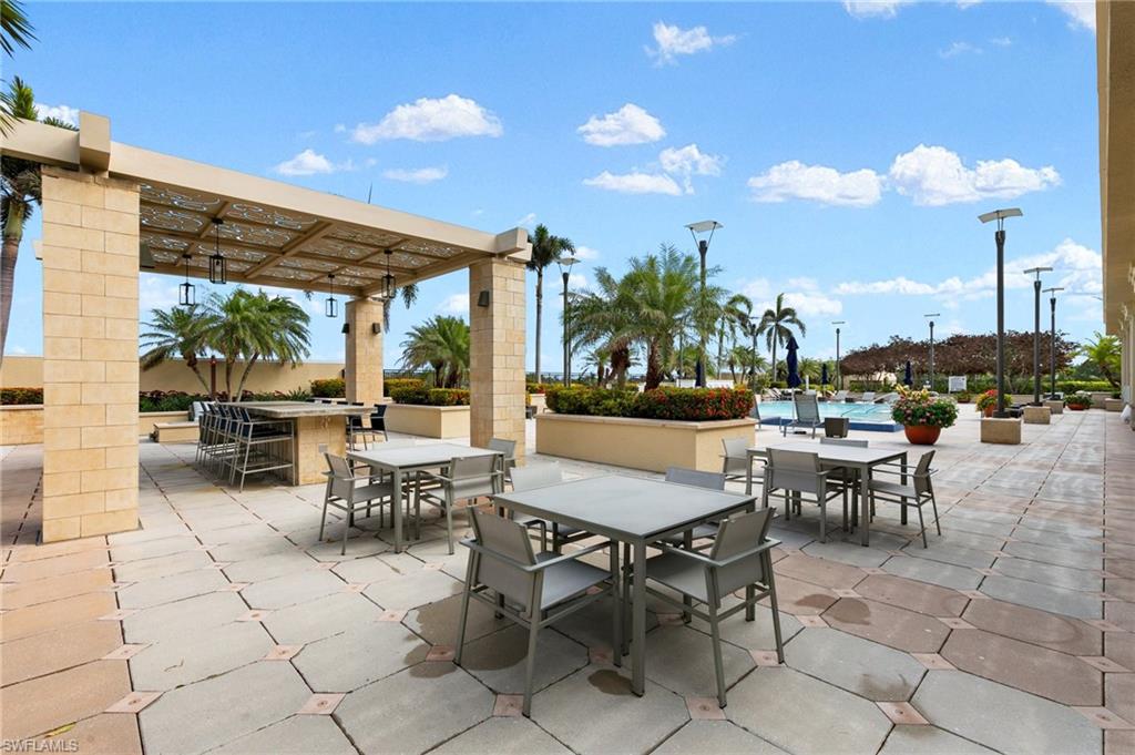 9115 Strada Place, Unit 5406 Naples, FL 34108 - Photo 46 of 50 a view of a patio with dining table and chairs with a patio