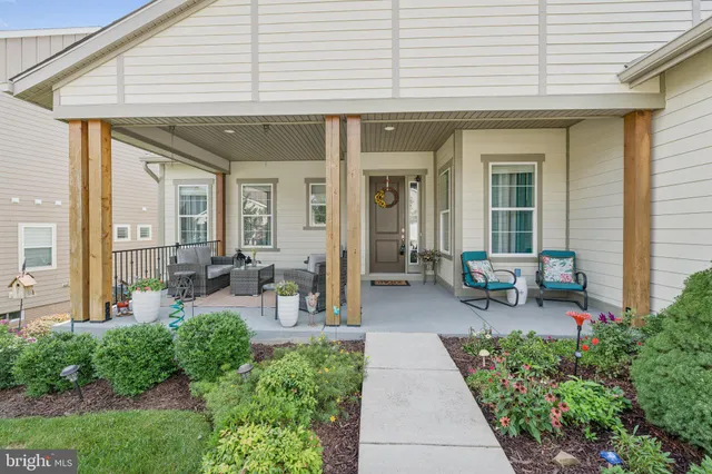 a view of a patio with table and chairs potted plants and floor to ceiling window