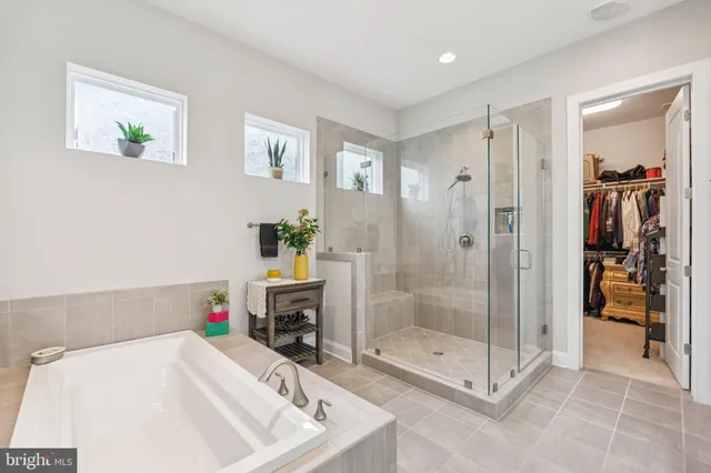 a bedroom with a bed a clock on the wall and a window