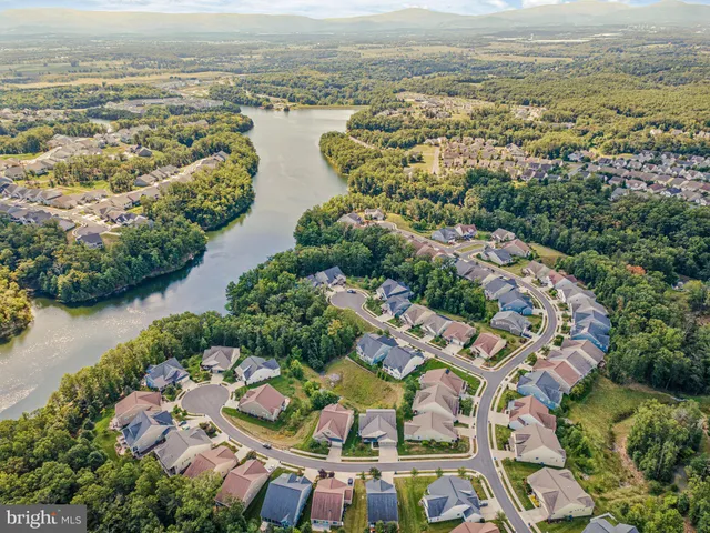 a kitchen with stainless steel appliances kitchen island granite countertop a table chairs and white cabinets