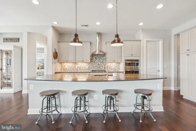 a large kitchen with stainless steel appliances lots of counter space and wooden floor