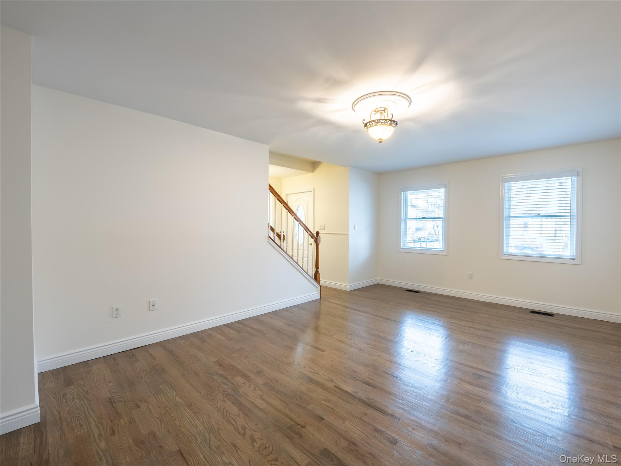 21 Marwood Road North Port Washington, NY 11050 - Photo 31 of 35 an empty room with wooden floor chandelier fan and windows