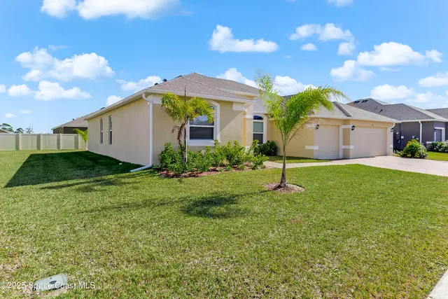 a backyard of a house with table and chairs