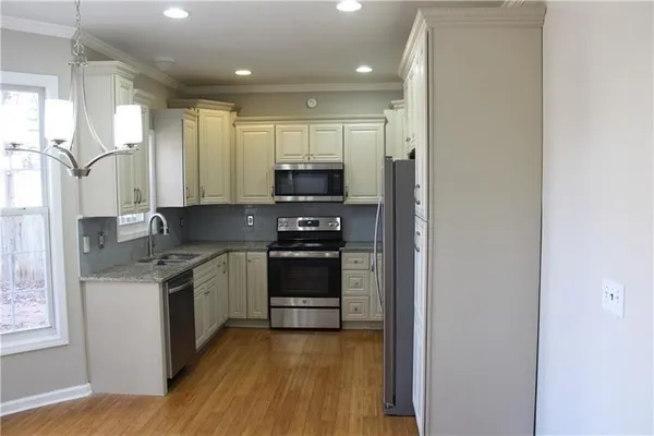 a kitchen with stainless steel appliances granite countertop a stove a sink and a refrigerator