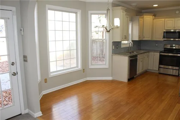 a kitchen with stainless steel appliances granite countertop a stove a sink and a refrigerator