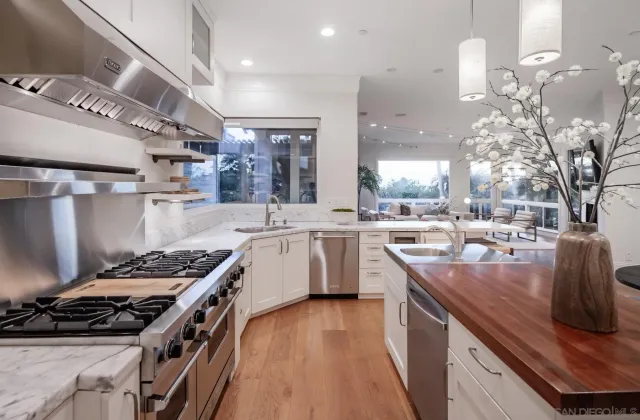 a kitchen with stainless steel appliances granite countertop a stove a sink dishwasher and cabinets with wooden floor