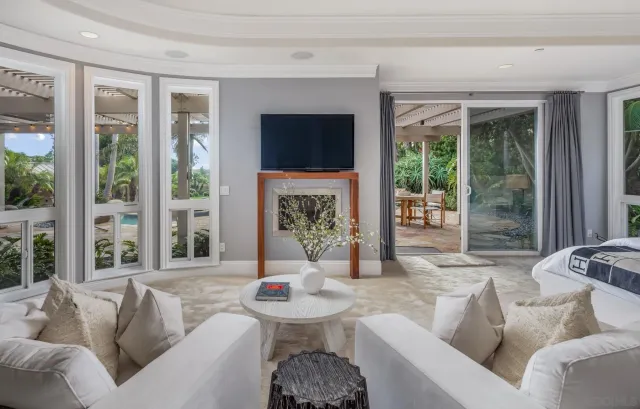 a living room with furniture a large window and a flat screen tv