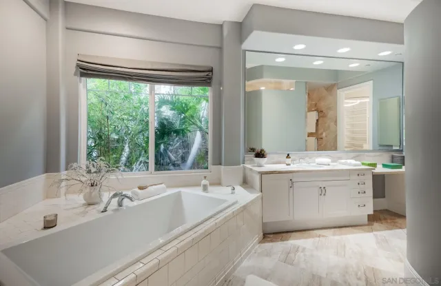 a bathroom with a tub sink and mirror