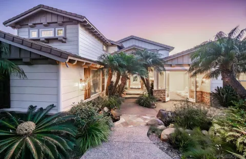 a view of a house with a yard and potted plants