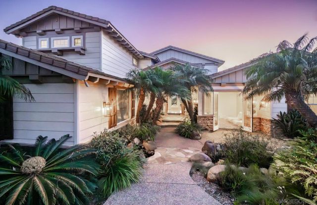 a view of a house with a yard and potted plants