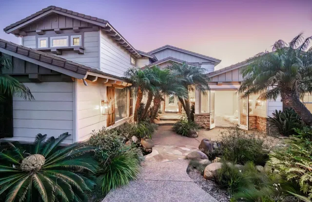 a view of a house with a yard and potted plants