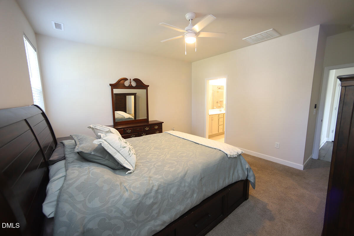 125 Mae Court Roxboro, NC 27573 - Photo 16 of 30 a bedroom with a bed and a chandelier