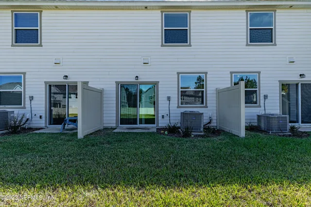 a view of a backyard with plants and large tree