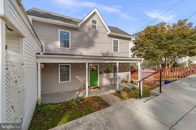 a view of a house with a yard and potted plants
