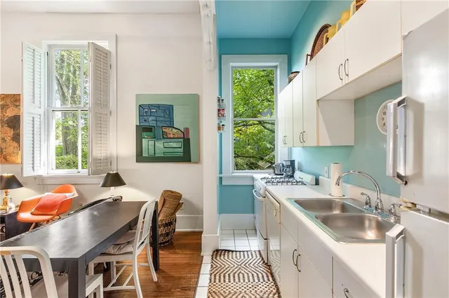 a kitchen that has a sink a counter top space and living room area