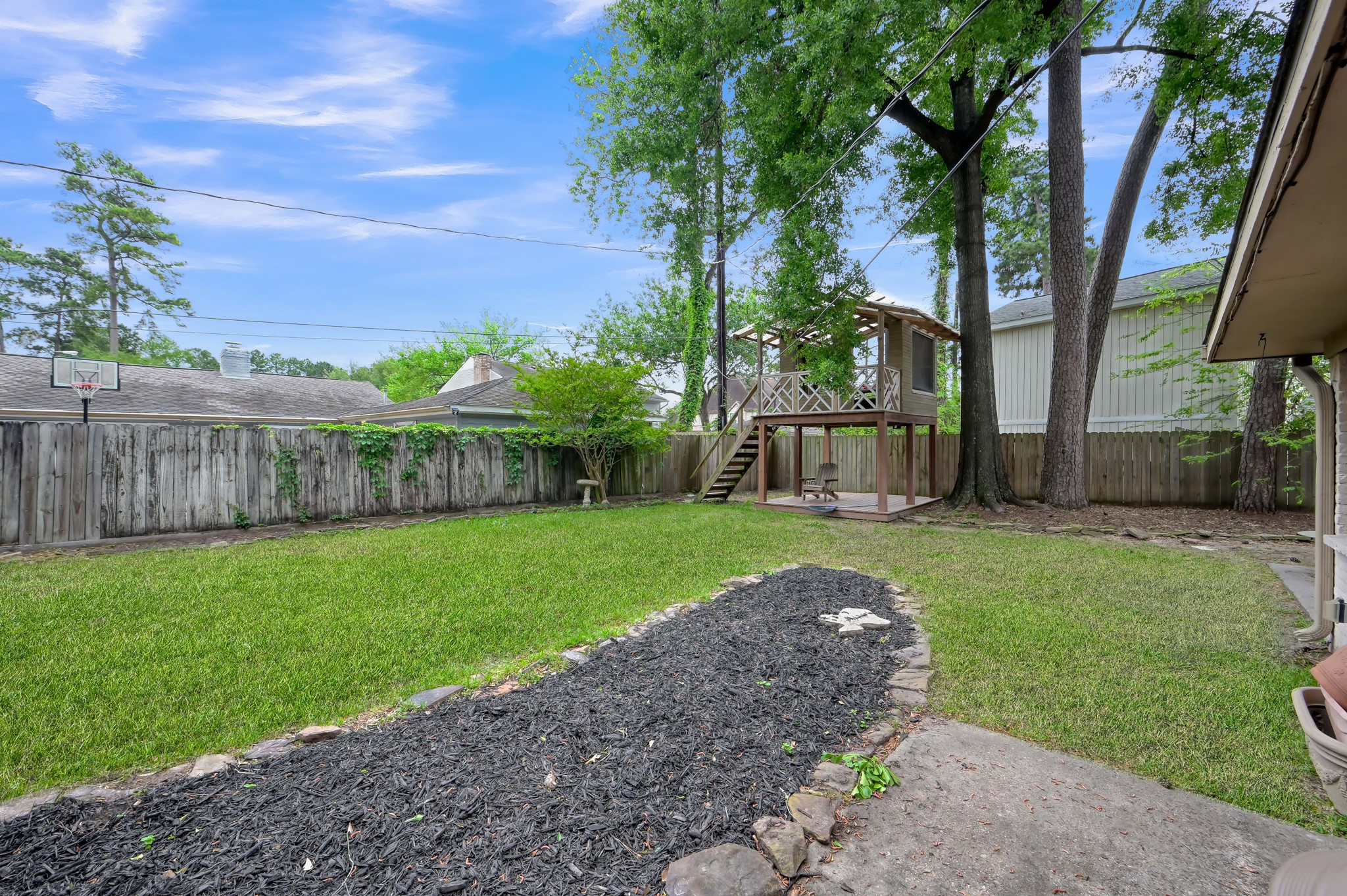 25610 Walnut Grove Circle Spring, TX 77380 - Photo 27 of 29 a view of a backyard with large trees and wooden fence