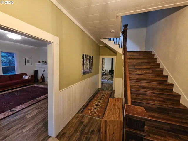 a view of a hallway with wooden floor and staircase