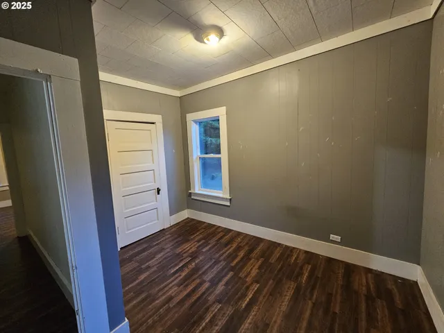 a view of a room with wooden floor and a window