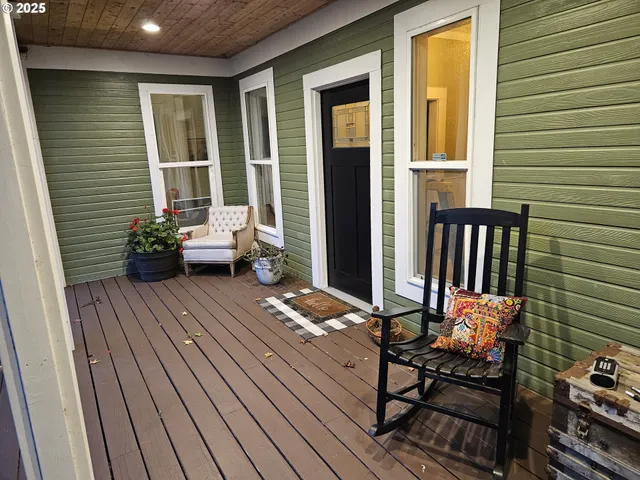 a balcony with wooden floor and outdoor seating