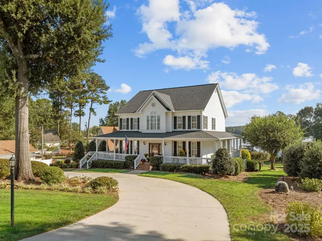 a front view of a house with a garden and trees