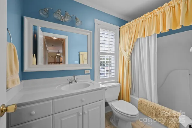 a spacious bedroom with a bed and a chandelier