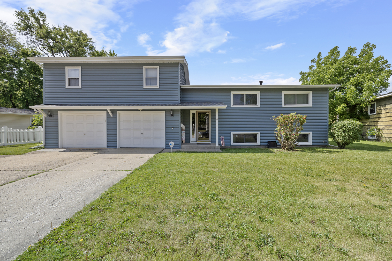 4 Saugatuck Road Montgomery, IL 60538 - Photo 1 of 24 a front view of a house with a yard and garage